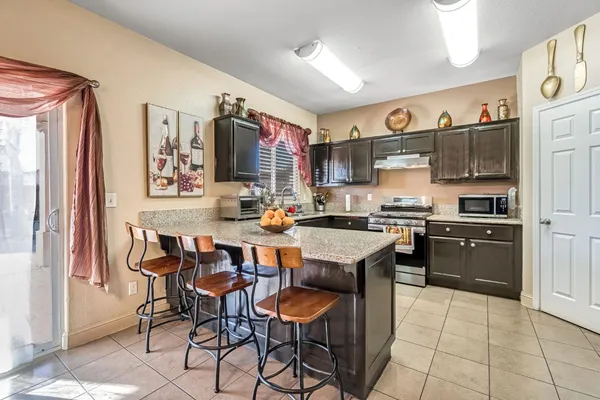 a kitchen with granite countertop stainless steel appliances a sink and a refrigerator