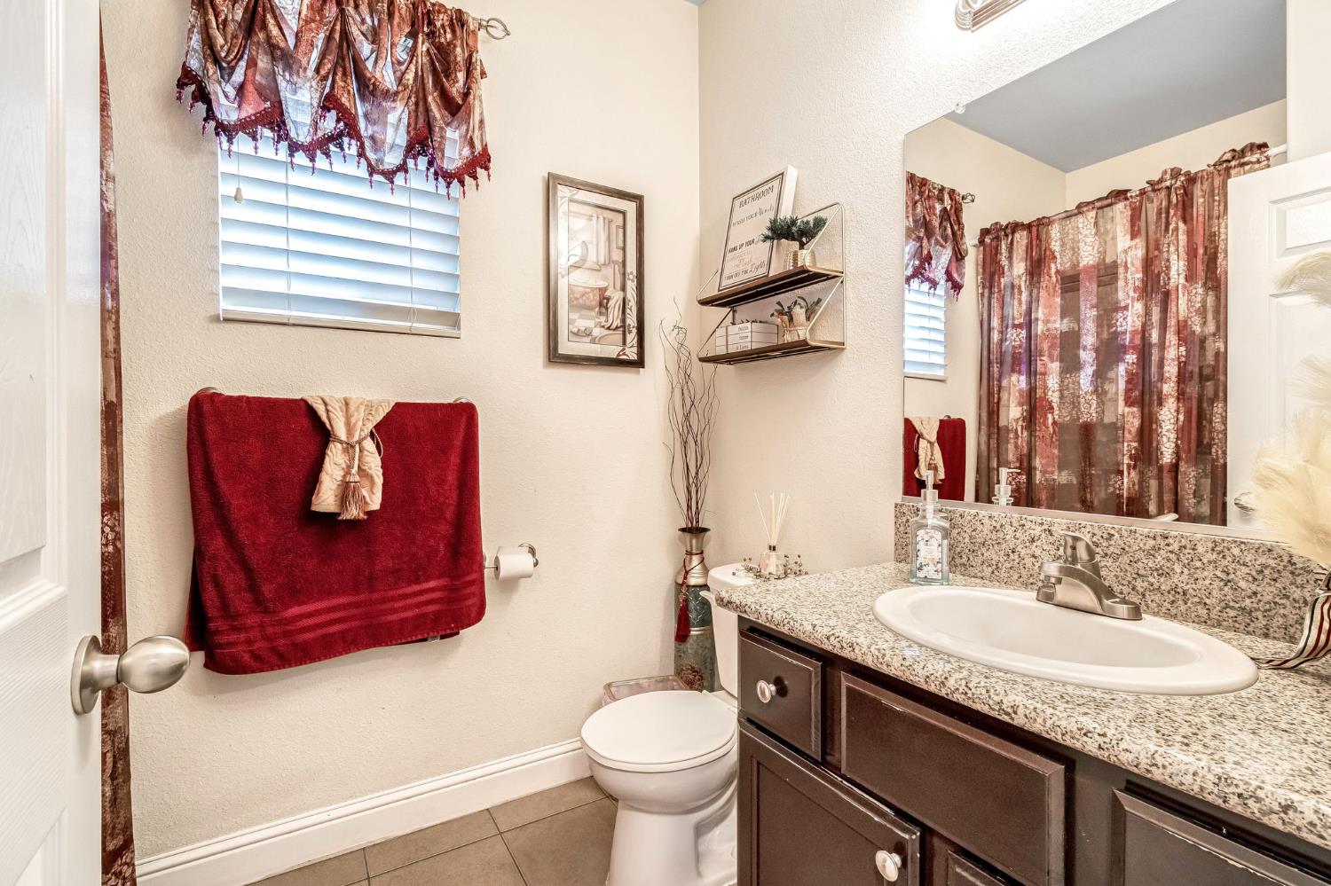877 Sandra Avenue Sanger, CA 93657 - Photo 16 of 40 a bathroom with a granite countertop sink toilet and a mirror