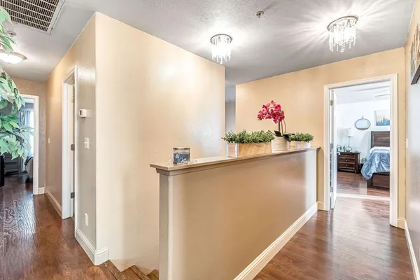 a view of hallway with furniture and wooden floor