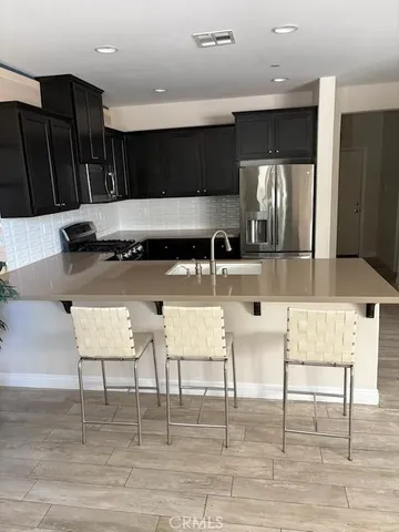 a kitchen with a table chairs refrigerator and microwave