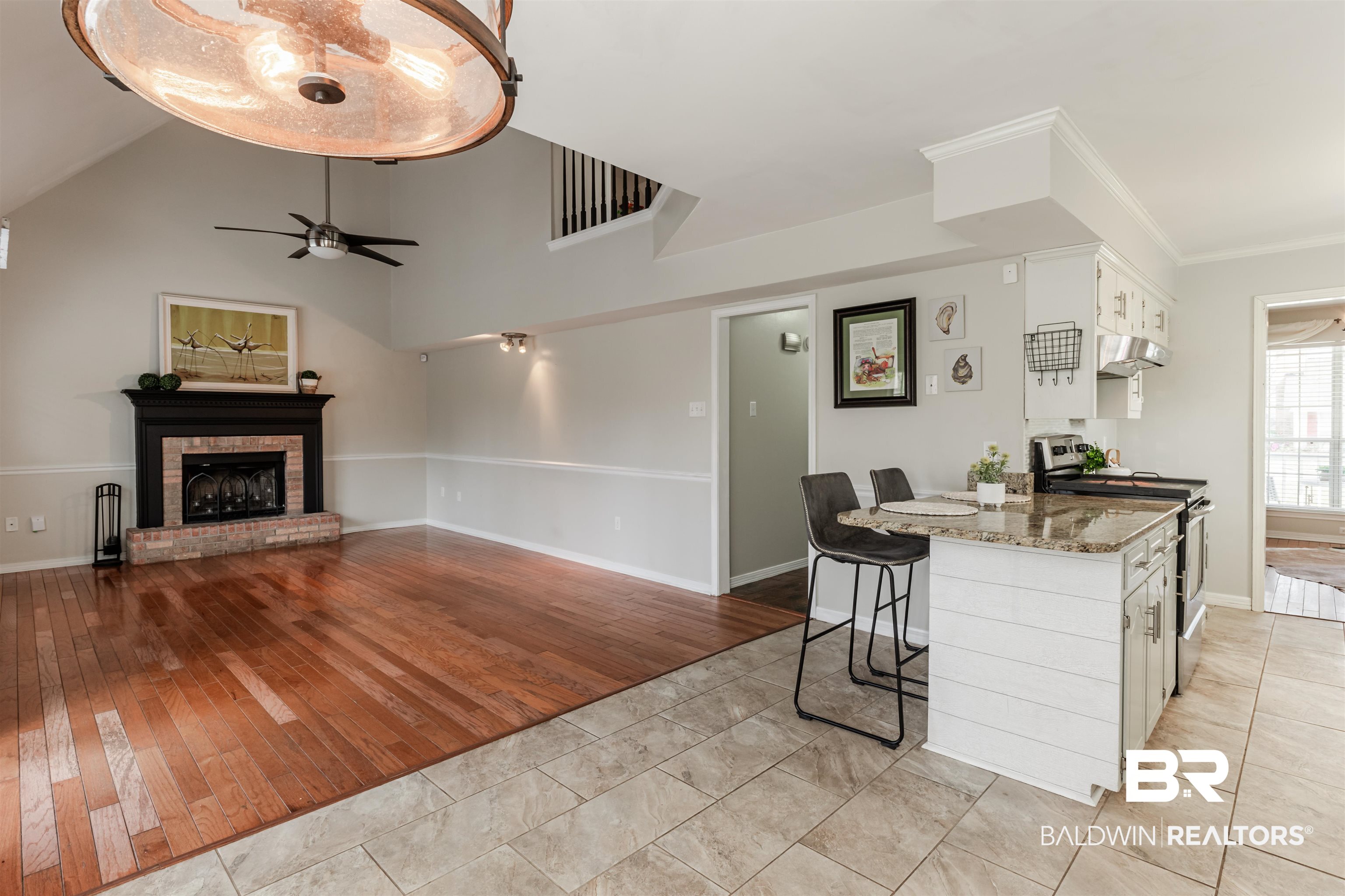 3844 Isabel Way South Mobile, AL 36693 - Photo 15 of 49 Kitchen featuring a breakfast bar area, stone countertops, stainless steel electric stove, a fireplace, and white cabinets