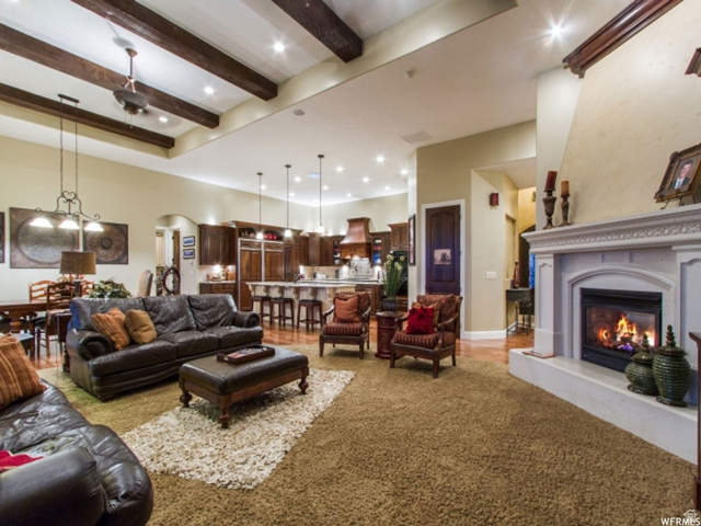 4378 Foothill Drive Bountiful, UT 84010 - Photo 14 of 46 Spacious living area featuring a stone fireplace, wood-finish flooring, and exposed ceiling beams