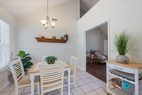 a dining room with furniture a chandelier and wooden floor