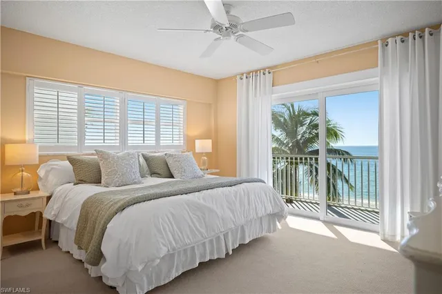 a bedroom with a balcony a bed and a chandelier