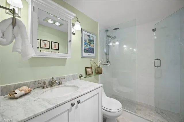 a bathroom with a granite countertop sink a toilet and a mirror