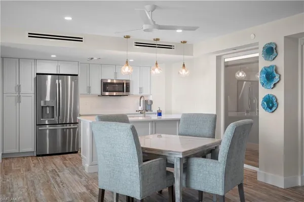 a kitchen with granite countertop a refrigerator and wooden floor