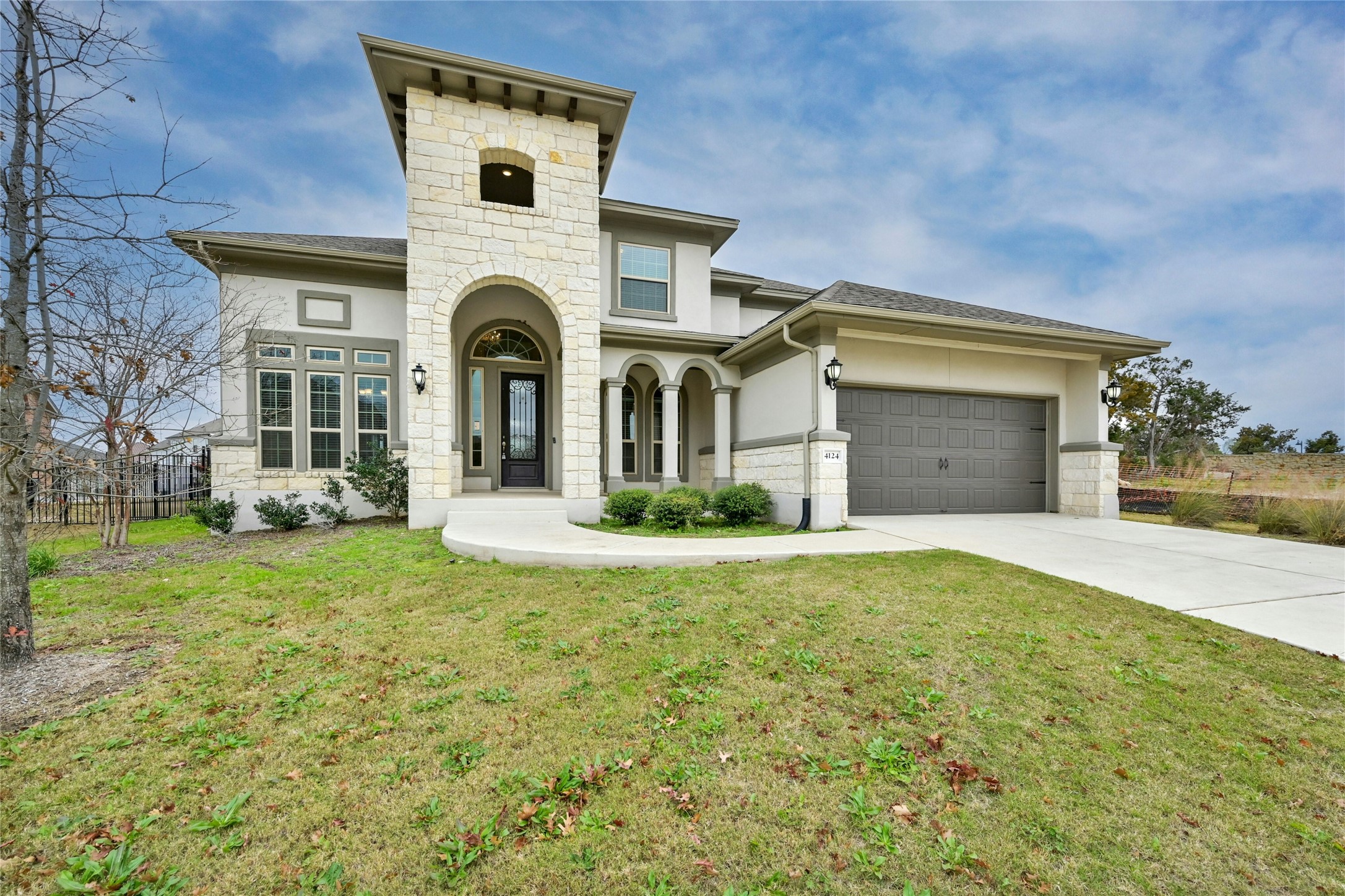 View of front facade featuring a garage and a front lawn