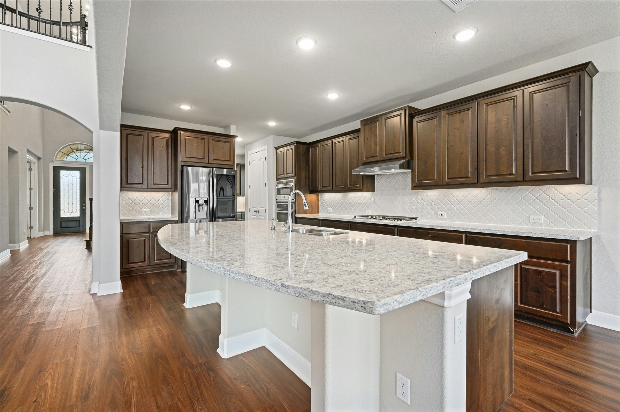 4124 Florentine Road Leander, TX 78641 - Photo 13 of 37 Kitchen featuring a center island with sink, sink, dark wood-type flooring, stainless steel appliances, and light stone counters