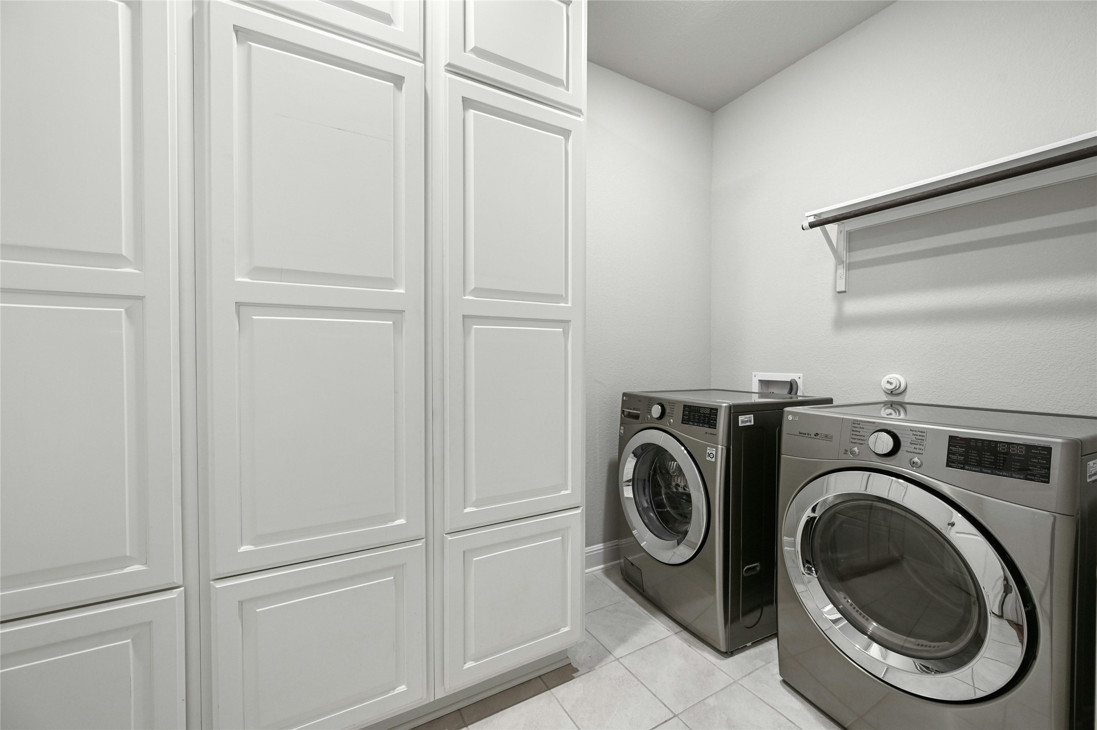 4124 Florentine Road Leander, TX 78641 - Photo 31 of 37 Laundry area featuring light tile patterned floors, cabinets, and washer and dryer