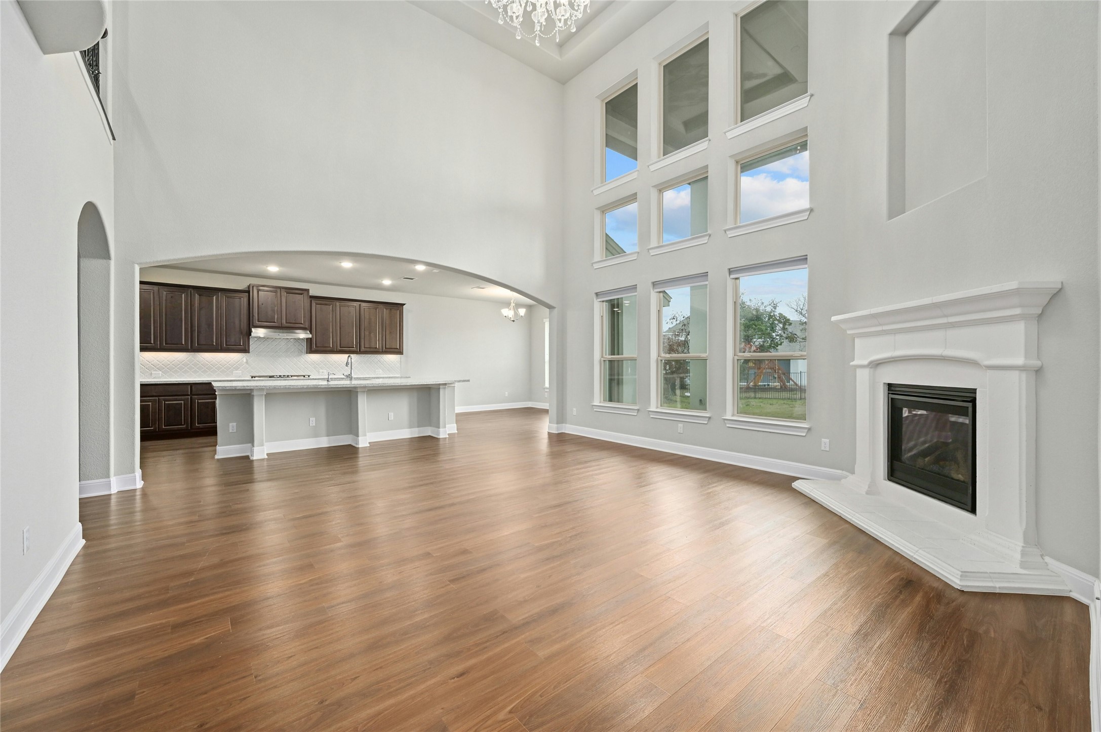4124 Florentine Road Leander, TX 78641 - Photo 8 of 37 Unfurnished living room featuring a high ceiling, dark hardwood / wood-style floors, and a chandelier