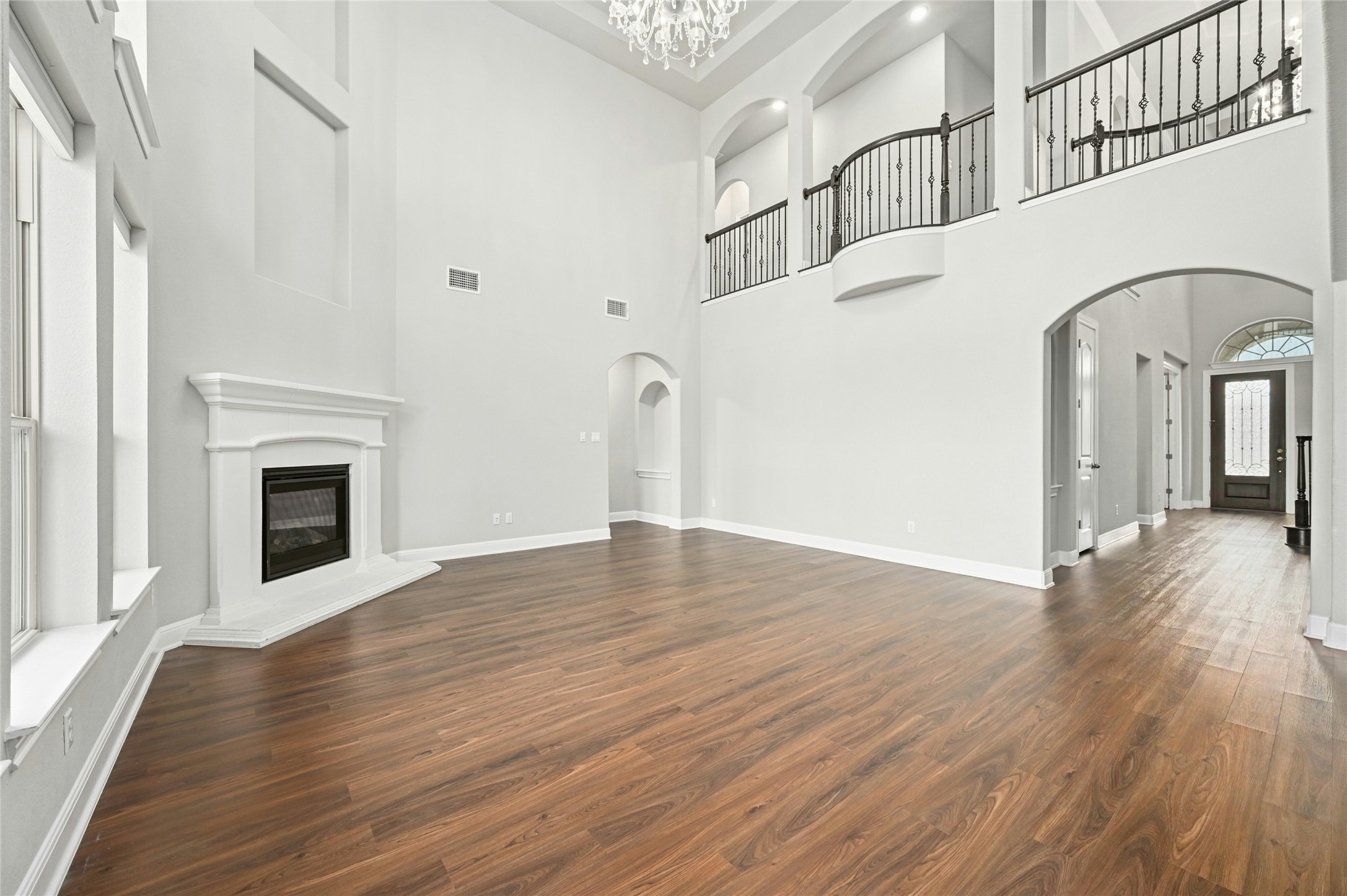4124 Florentine Road Leander, TX 78641 - Photo 9 of 37 Unfurnished living room featuring an inviting chandelier, a towering ceiling, and dark hardwood / wood-style floors