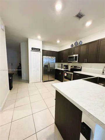 a kitchen with stainless steel appliances a refrigerator sink and microwave