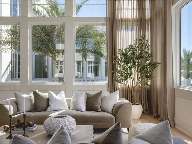 a living room with furniture and large windows