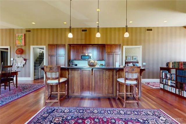 a kitchen with stainless steel appliances a dining table chairs stove and cabinets