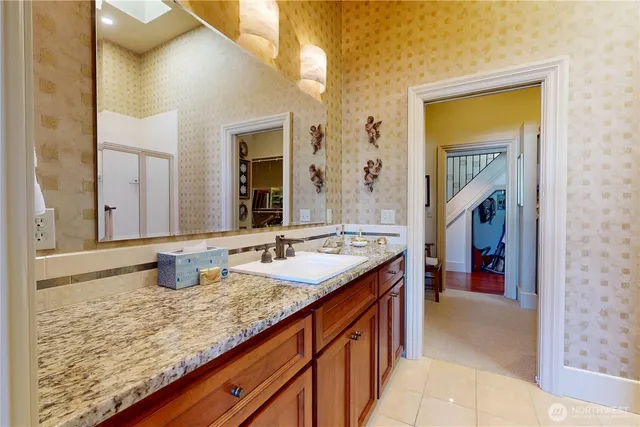 a bathroom with a granite countertop sink and a mirror