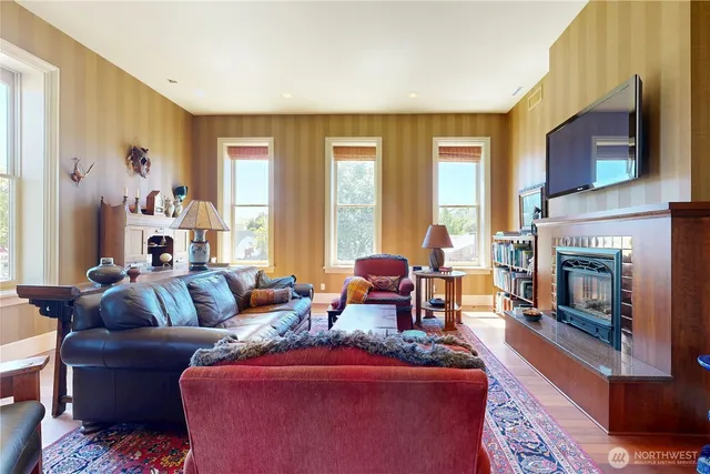 a living room with furniture a fireplace and a flat screen tv