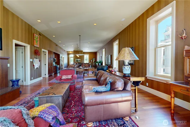a living room with furniture kitchen view and a large window
