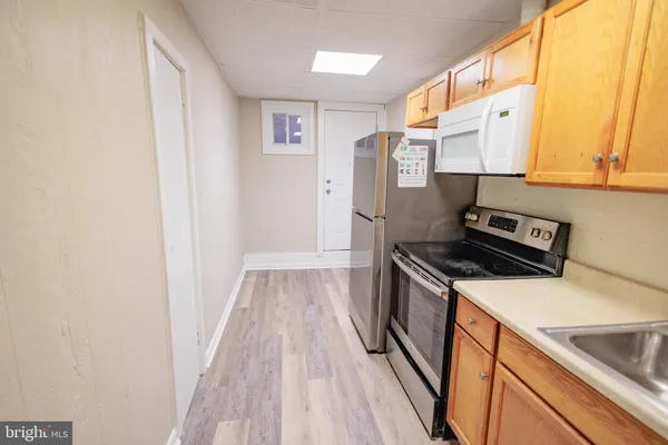 a kitchen with a refrigerator and a stove top oven