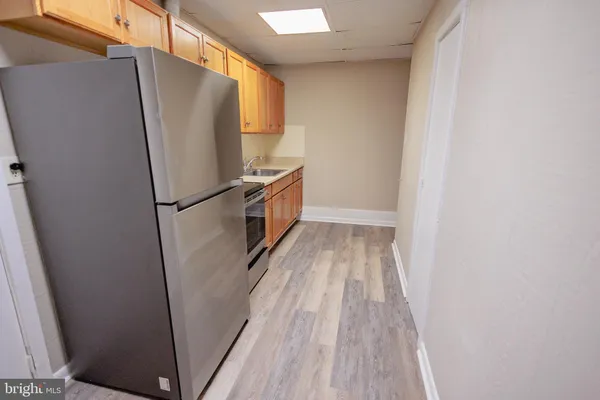 a view of a kitchen with wooden floor and a refrigerator