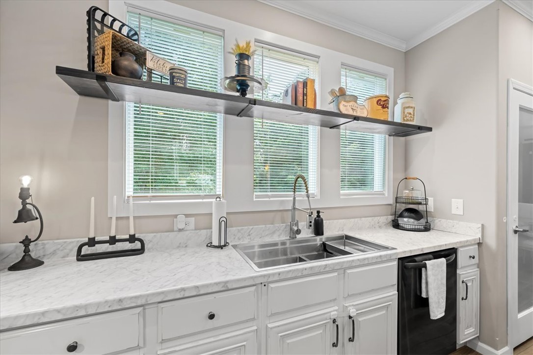 116 Parkview Road Iva, SC 29655 - Photo 9 of 44 A pristine kitchen offers ample counter space, a double sink, and sleek white cabinetry for culinary pursuits.