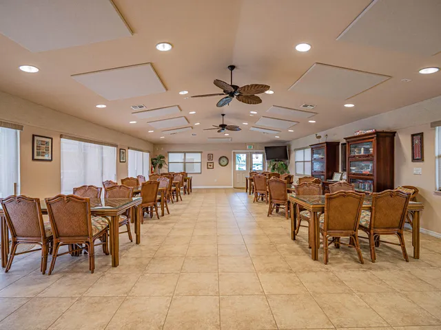 a large dining space with furniture a rug and chandelier