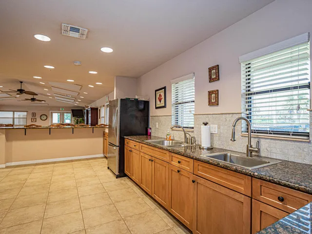 a large kitchen with stainless steel appliances a sink and a refrigerator