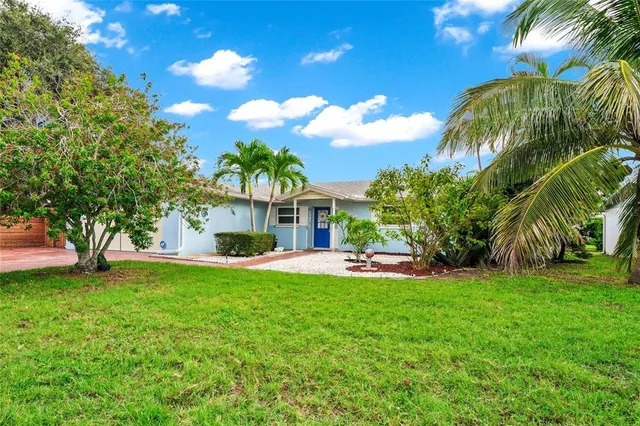 a view of a house with a yard and palm tree