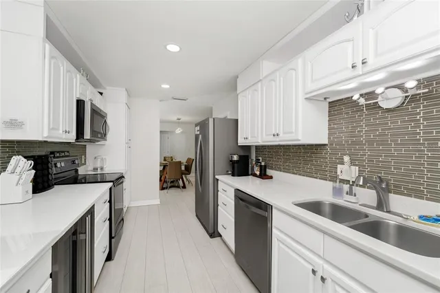 a kitchen that has a sink a stove and cabinets