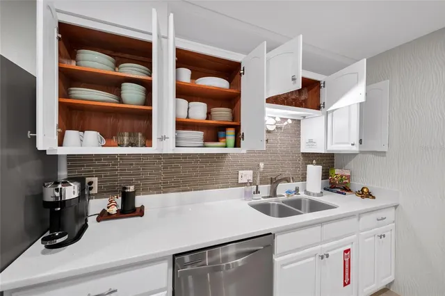 a kitchen with white cabinets a sink and a stove