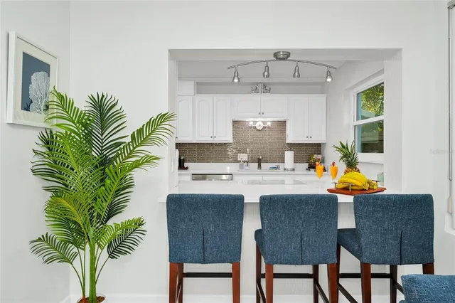 a kitchen with a table chairs and white cabinets