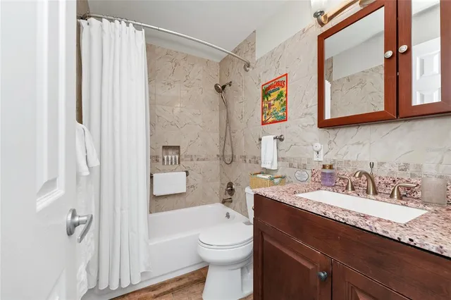 a bathroom with a granite countertop toilet a sink and a mirror