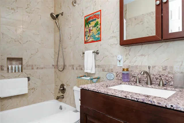 a bathroom with a granite countertop sink mirror and bathtub