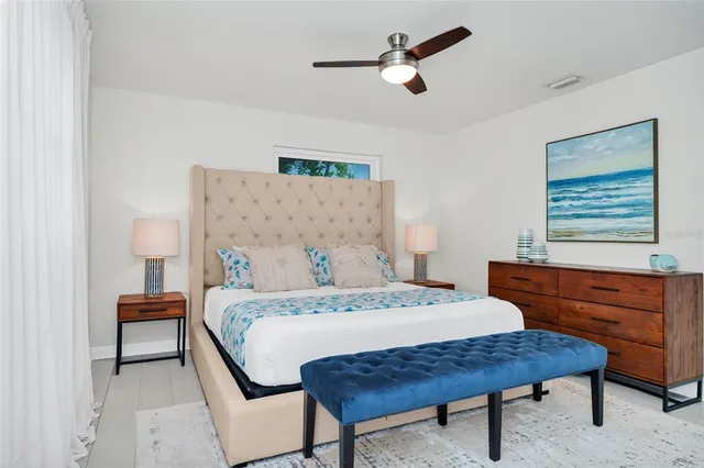 a bedroom with a bed a dresser and a window