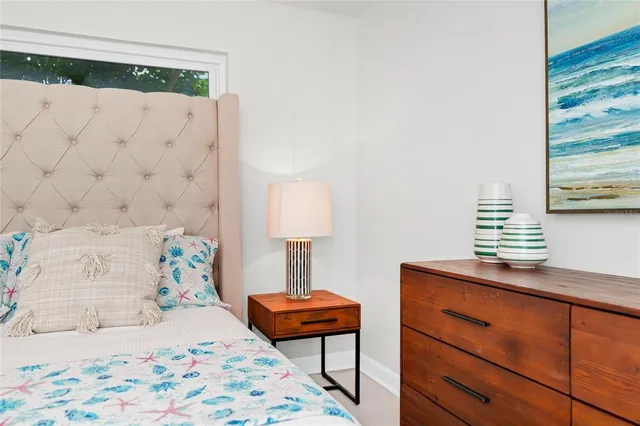 a bedroom with a bed and a lamp on the dresser