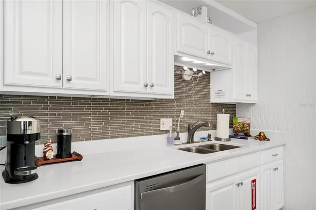 a kitchen with white cabinets and a sink