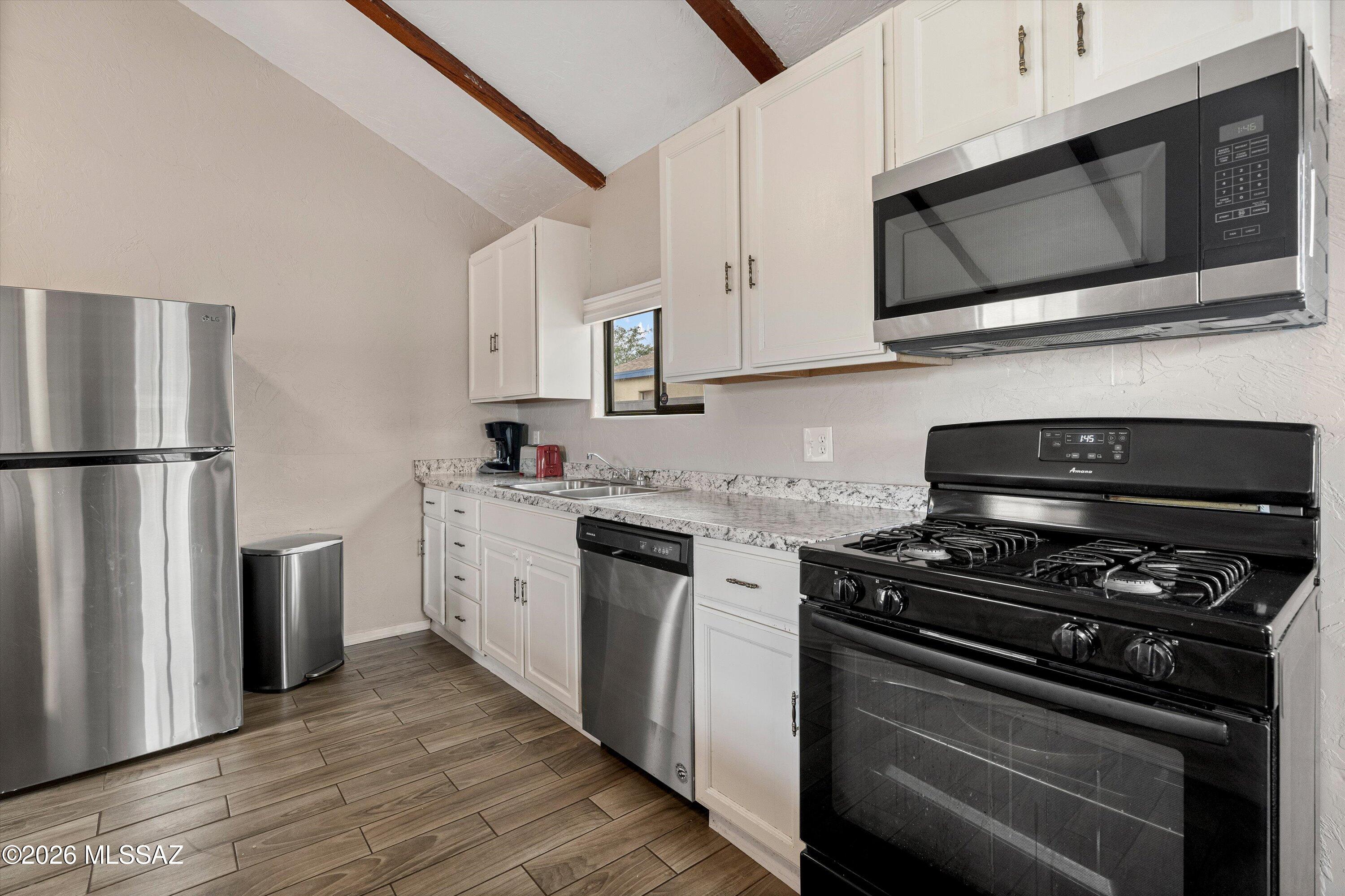 2841 North Richey Boulevard Tucson, AZ 85716 - Photo 12 of 30 a kitchen with stainless steel appliances a stove microwave and sink