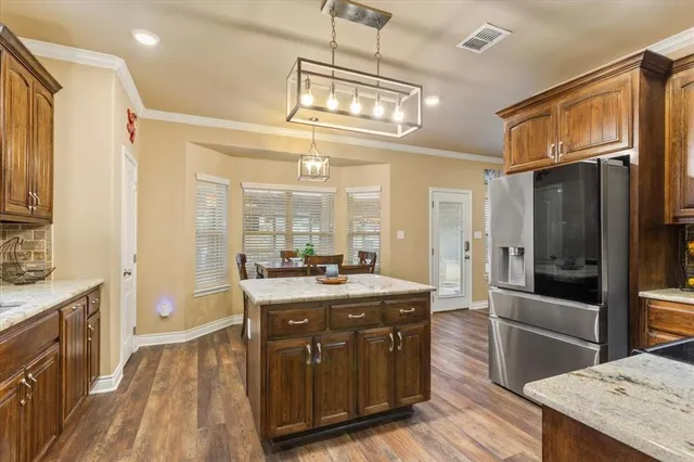 a kitchen with stainless steel appliances granite countertop a sink a stove and a refrigerator