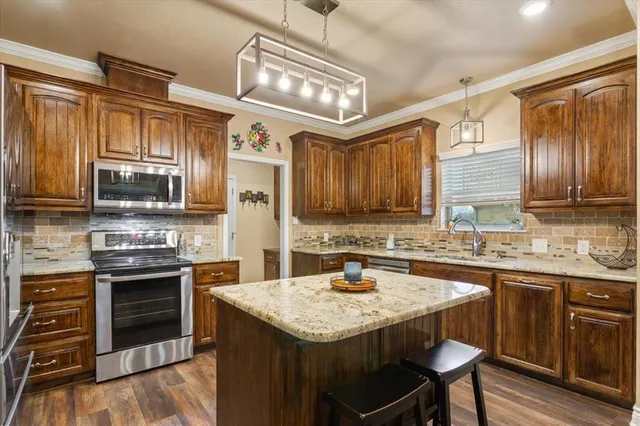 a kitchen with stainless steel appliances granite countertop a sink stove and refrigerator