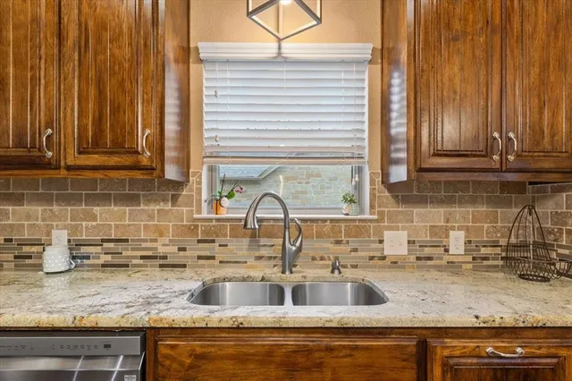 a kitchen with granite countertop a sink and a wooden cabinets