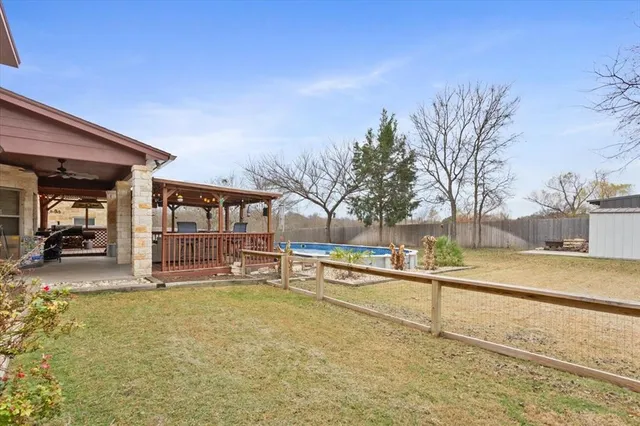 a view of a swimming pool with a bench and trees