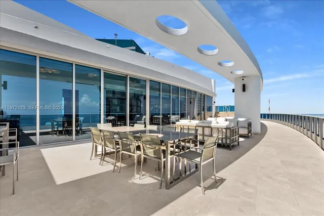 a living room with furniture and floor to ceiling windows