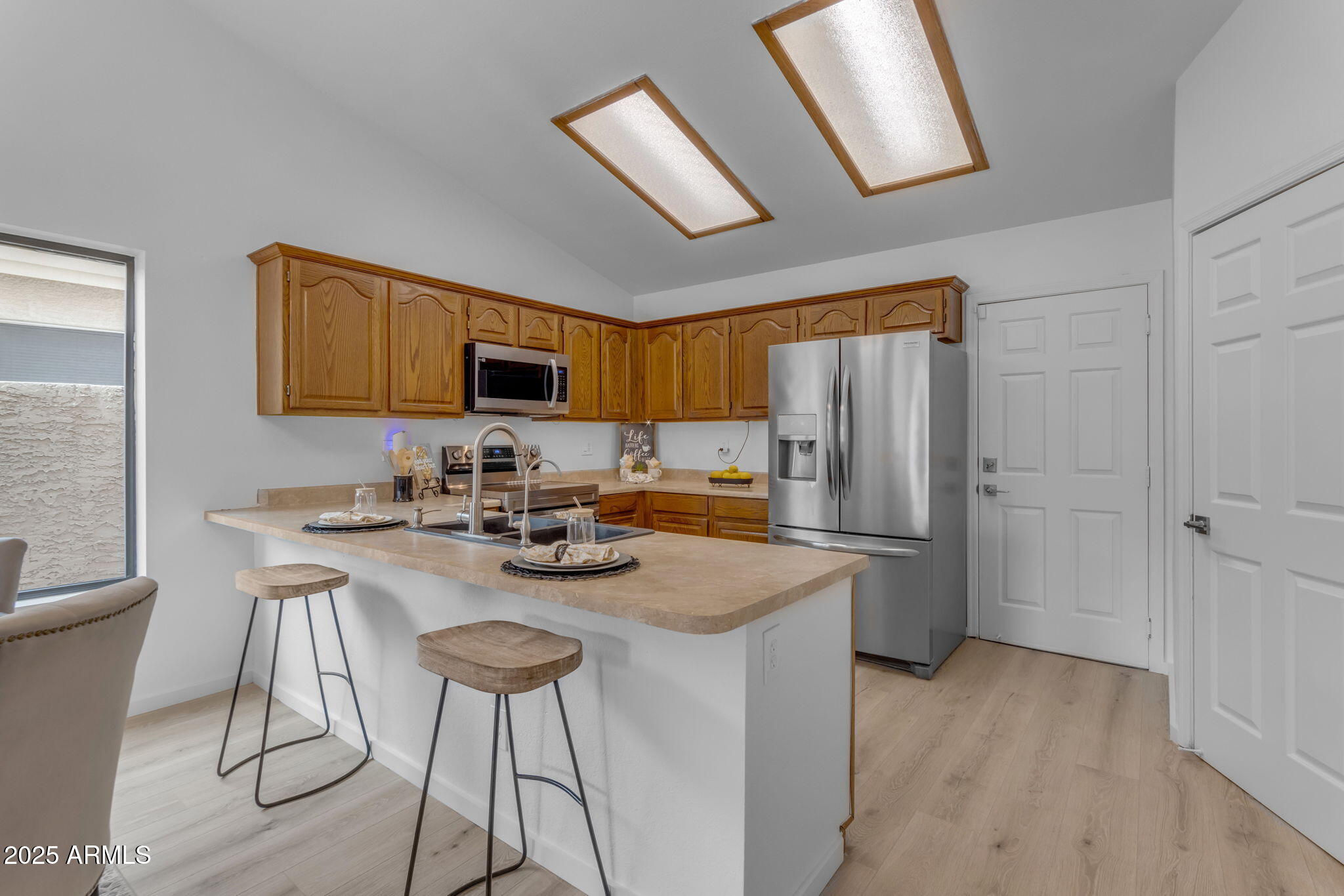 137 West Gary Way Gilbert, AZ 85233 - Photo 6 of 43 a kitchen with stainless steel appliances granite countertop a stove a refrigerator a sink a dining table and chairs with wooden floor
