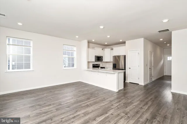 a view of kitchen with stainless steel appliances refrigerator stove microwave and cabinets