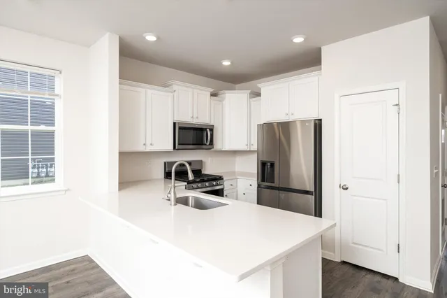 a kitchen with stainless steel appliances a refrigerator sink and microwave