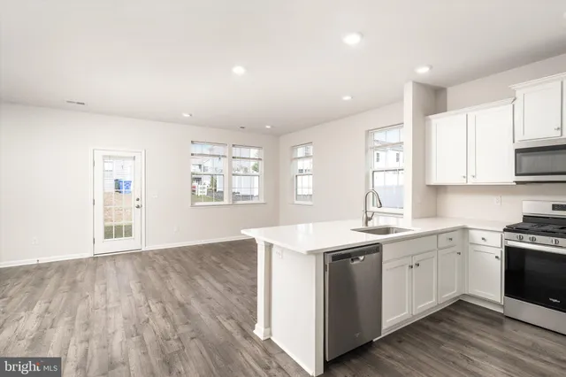 a kitchen with a sink wooden floor and window