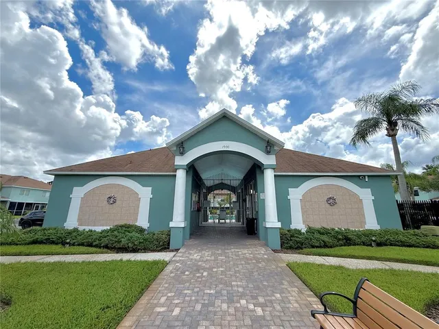 a view of a wooden house with a yard plants and a large tree