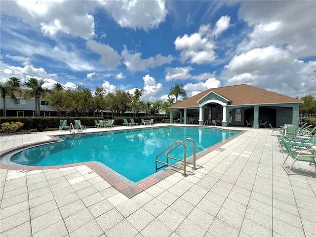 a view of house with swimming pool and yard