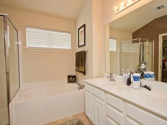 a bathroom with a tub a sink and mirror