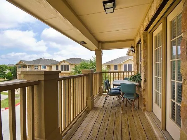 a view of a balcony with wooden chairs