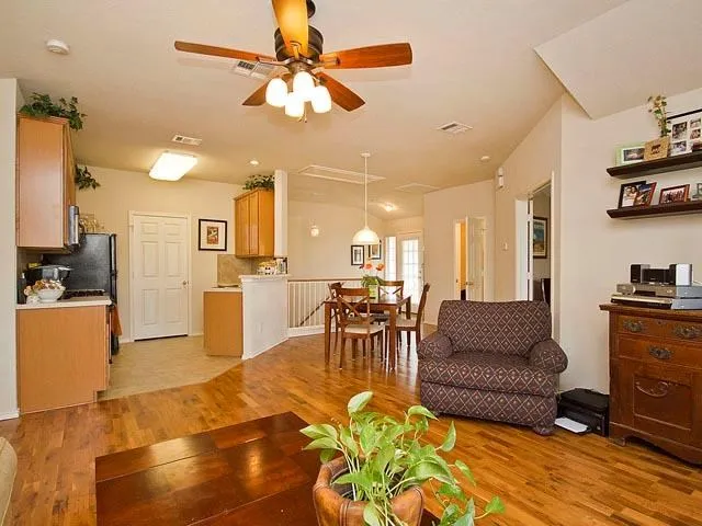 a living room with furniture kitchen view and a chandelier